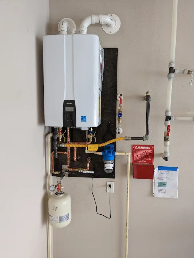 Professional plumber installing copper piping in a Carterville home